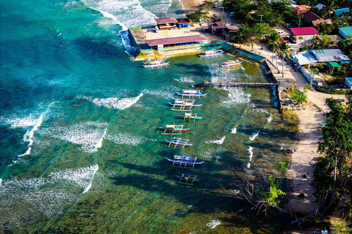 Traditional outrigger boats on clear blue water off the Palawan coast.
